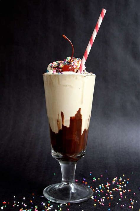A Chocolate Milkshake With Sprinkles And A Candy Cane In It