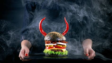 Devil Burger With Bacon And Vegetables On Black Slat Plate Stock Image