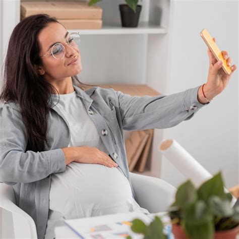 free photo pregnant woman taking selfie at home while working