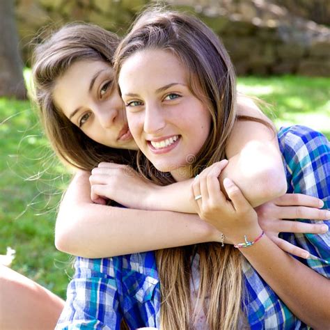 Dos Novias Felices Del Adolescente Que Abrazan En El Parque Que Mira La Cámara Imagen de archivo