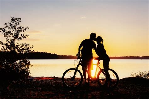 Premium Photo Couple On A Bicycle At Sunset By The Lake