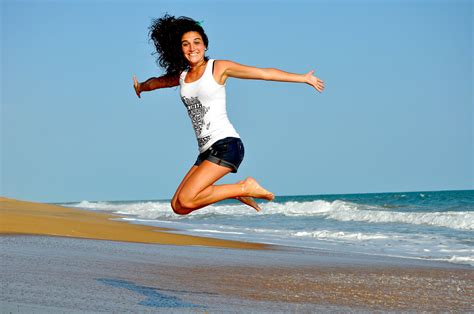 Fitness Woman Jumping At The Beach