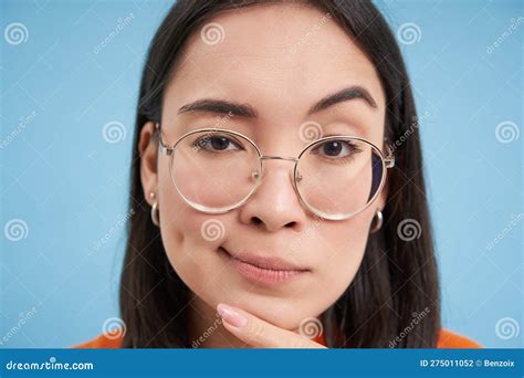 Close Up Portrait Of Asian Woman Looks Intrigued Wears Glasses Squints Thoughtful Thinking