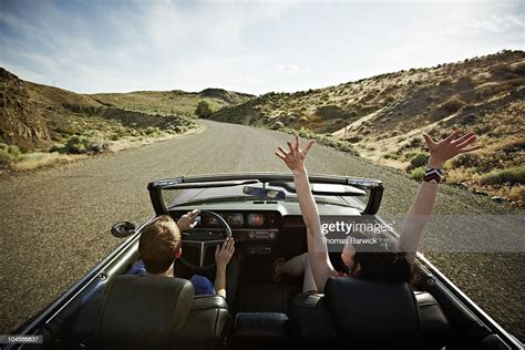 Couple Driving Convertible On Desert Road Photo Getty Images