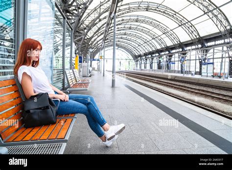 Girl Waiting For Train At Station Sitting On Bench Stock Photo Alamy