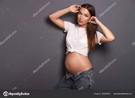 Sexy Brunette Pregnant Woman With Long Hair And In Jeans And Whi Stock
