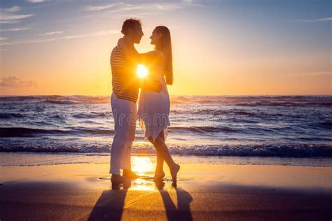 Romantic Couple In Love Kissing On The Beach During Sunset Stock Photo