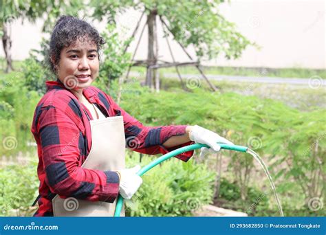 Happy Asian Female Watering With A Hose In Agriculture Farming Woman