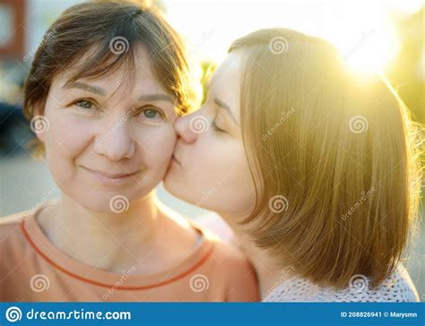 Loving Adult Daughter Hugs And Kisses Her Mature Mom A Tender