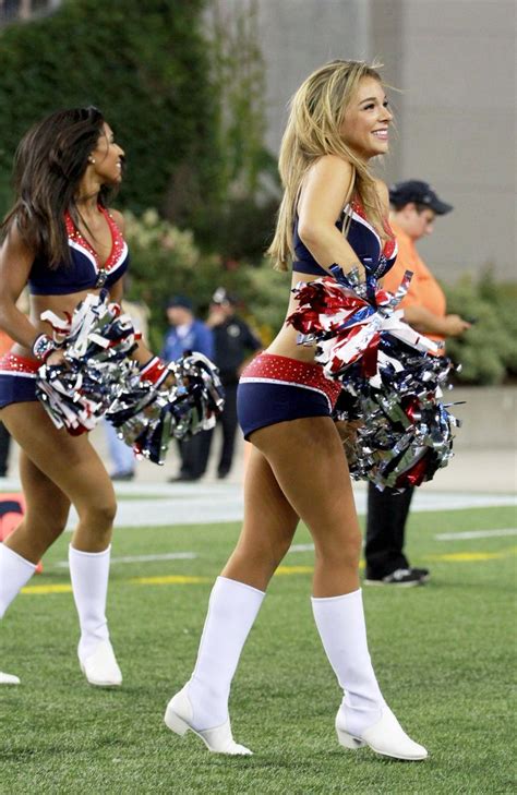 two cheerleaders in red white and blue outfits are dancing on the field