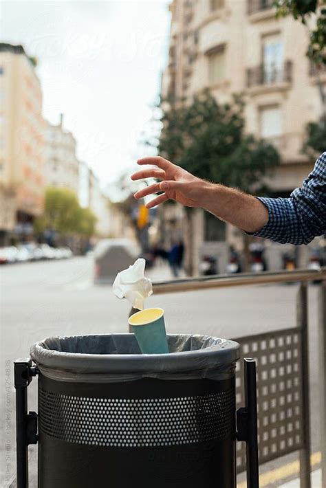 Man Throwing Trash Into Bin In The City