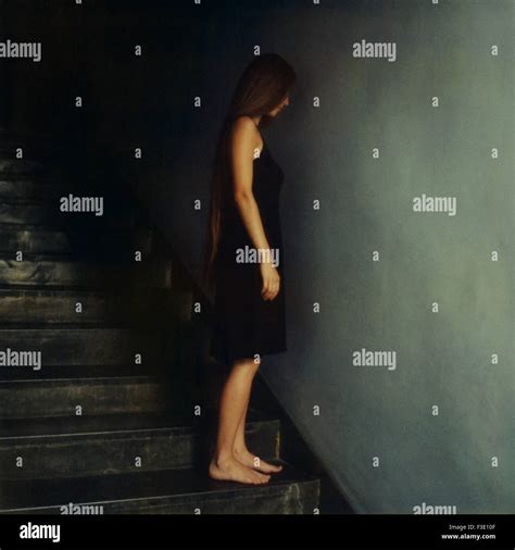 Woman Standing On Stairs Facing Wall Stock Photo Alamy