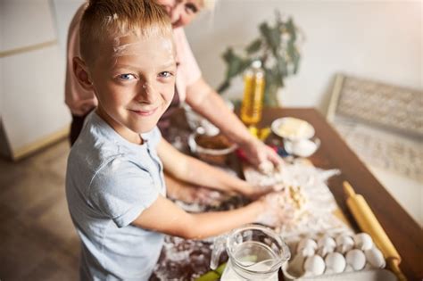 Niño Feliz Disfrutando De La Cocina Con Su Amable Abuela Foto Premium