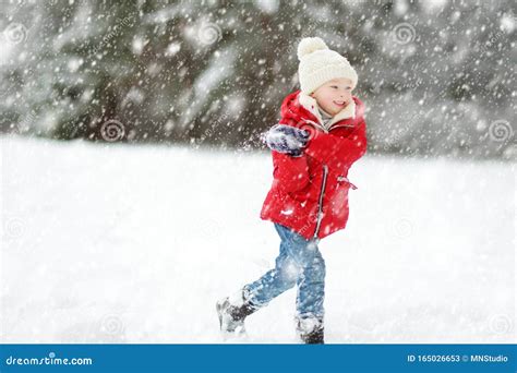 Adorable Young Girl Having Fun In Beautiful Winter Park During Snowfall