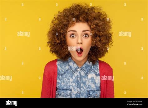 wow unbelievable closeup portrait of excited amazed woman with fluffy curly hair looking with