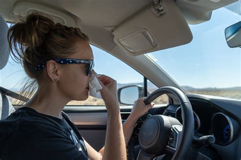 Woman Female Driver Uses A Tissue To Blow Her Nose While Driving Stock