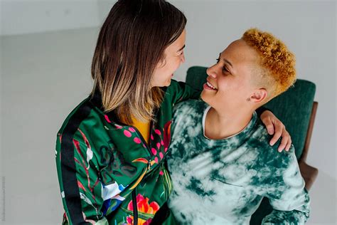 happy lesbian couple in green chair by stocksy contributor erin brant stocksy