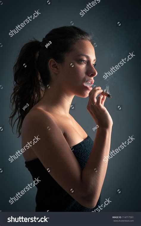 Woman Smoking Cigar Against Dark Background Stock Photo 114717391