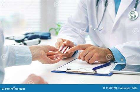 Doctor Prescribing Medicine To A Patient In The Office Stock Photo