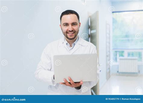 Portrait Of Cheerful Doctor Sitting At The Desk Working On Laptop Stock Image Image Of Medical
