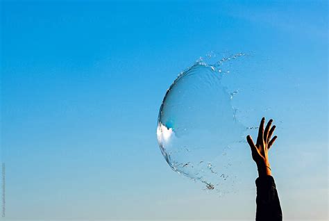 Hand Reaching Up To Pop A Big Bubble By Stocksy Contributor Carolyn Lagattuta Stocksy