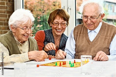 Elderly Couple And Daughter Playing Board Game Stockfotos Und