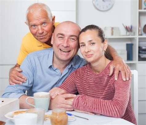 mature man with daughter and her husband at table with cup of tea stock image image of