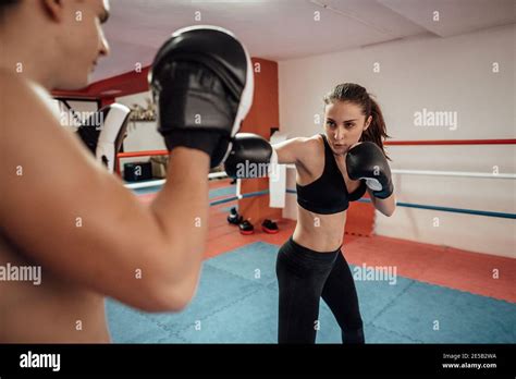 A Front View Of A Female Kick Boxer Training Punches With A Partner A