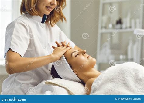 Cosmetologist Or Dermatologist Making Facial Beauty Massage Treatment For Young Woman In Beauty