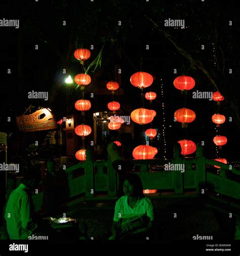 A Couple Talk Outdoors At Night Illuminated By Chinese Lanterns