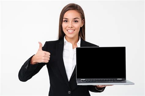 glückliche hübsche geschäftsfrau die anzeige des laptops mit daumen hoch zeigt kostenlose foto