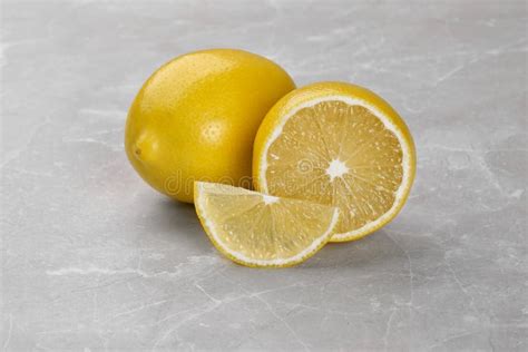 Whole And Cut Fresh Ripe Lemons On Grey Marble Table Stock Image