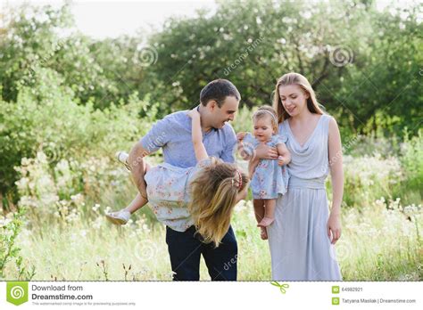 Mamá Y Papá Que Juegan En La Naturaleza Y Que Abrazan Dos Hijas Fotos