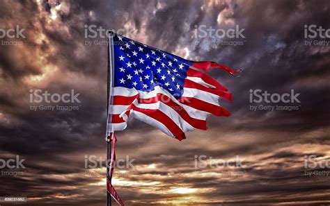 Tattered American Flag Flapping In Ominous Sky Stock Photo Download