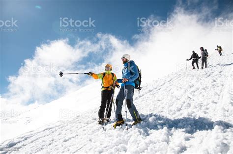 Fully Equipped Professional Climbers Descend Down The Snowy Slope In