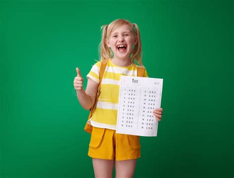 Smiling School Girl With Excellent Grade Test Showing Thumbs Up Stock