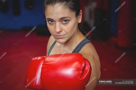Confident Female Boxer Performing Boxing Stance In Fitness Studio