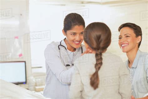 Female Pediatrician Checking Neck Lymph Node Glands Of Girl Patient In