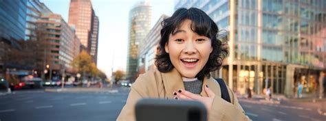 Premium Photo Portrait Of Asian Girl Looks Surprised At Smartphone Screen Video Chats And