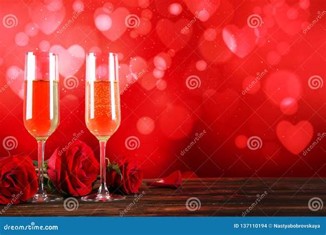 Champagne For Couple In Love In Two Flutes On Table With Red Tablecloth