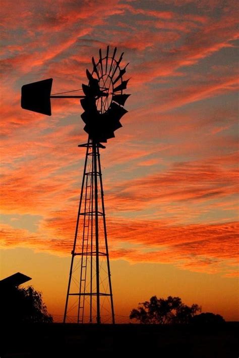 Australian Windmill Sillhouetted Against A Beautiful Red Sunset Old