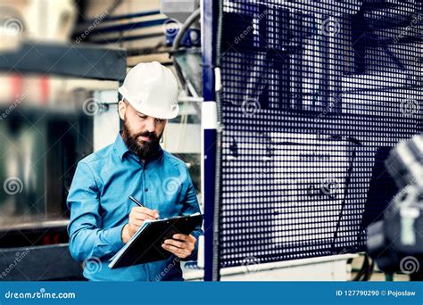 A Portrait Of An Industrial Man Engineer With Clipboard In A Factory