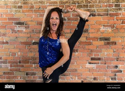 A Flexible Yogic Instructor Flaunts Her Skills During A Yoga Class With Wide Opened Mouth As