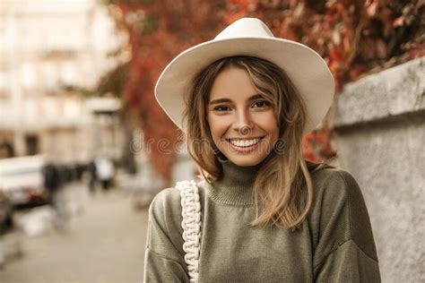 Close Up Young European Lady Smiling Teeth While Looking At Camera Against Blurred Urban
