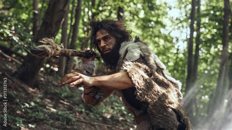 Portrait Of Primeval Caveman Wearing Animal Skin And Fur Hunting With A