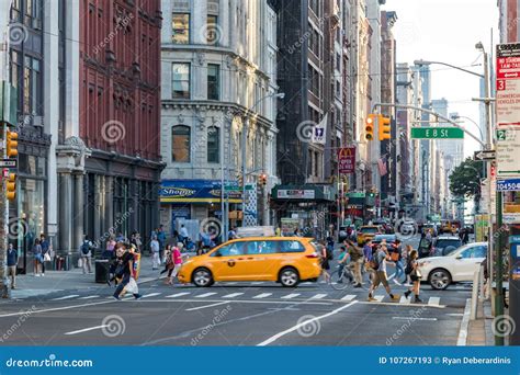 People And Cars Cross The Busy Intersection Of Broadway And 8th Street