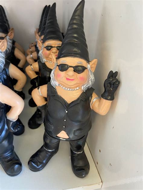A Group Of Gnome Figurines Sitting Next To Each Other On Top Of A Shelf