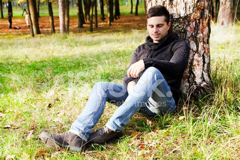 Young Man Sitting Under A Tree Stock Photo Royalty Free Freeimages