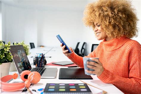 Black Woman Using Smartphone In Office By Stocksy Contributor Santi Nu Ez Stocksy