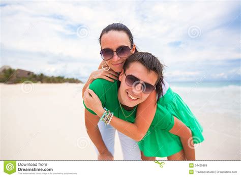Pares Jovenes Felices En La Playa Exótica Que Mira Imagen De Archivo